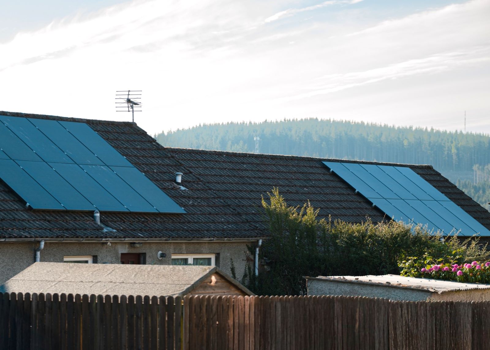 A generic image of domestic solar panels on the rooftop of small homes